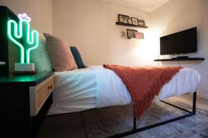 a bedroom with a bed with a desk and a tv at Midnight Modern in San Jose