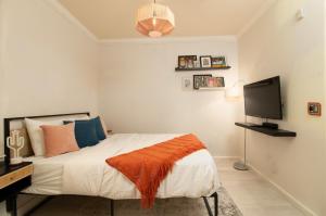 a bedroom with a bed and a flat screen tv at Midnight Modern in San Jose