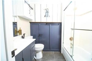 a bathroom with a toilet and a blue door at Midnight Modern in San Jose +7 photos