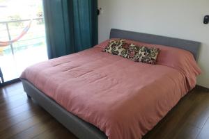 a bed with two pillows on it in a bedroom at Villa Nomad in Naranjito