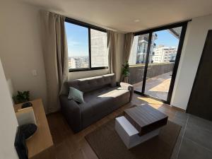 a living room with a couch and a large window at Suite Privada Zona Norte in Miravalle