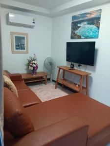 a living room with a couch and a flat screen tv at แอนนา เรสซิเดนซ์ in Ban Dung