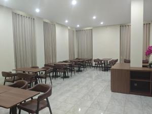 a dining room with tables and chairs and curtains at green hotel 2 ciamis in Ciamis