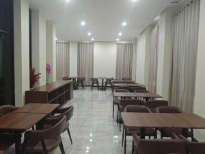 a row of tables and chairs in a restaurant at green hotel 2 ciamis in Ciamis
