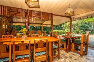 a dining room with wooden tables and chairs at Casa el Tortugo in Drake