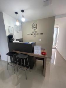 a reception desk in a room with two stools at Hotel Portal Del Cerro Manizales in Manizales