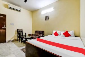 a bedroom with a bed and a desk and a chair at Hotel O Lord Shiva in Bankipur