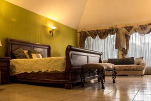 a bedroom with a bed and a chair and a couch at Mi casa, tu casa in Guatemala