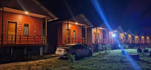 a car parked next to a row of houses at night at Konglor cave Resort - River side Restaurant in Ban Konglo +1 photo