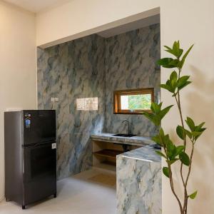 a kitchen with a black refrigerator and a sink at CASA Habibi in Kuta Lombok