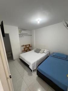 a bedroom with two beds in a room at HOSTAL CARACOLI - HUECO in Valledupar