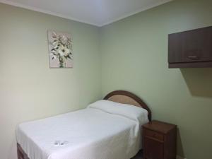 a small bedroom with a bed and a tv at Hostal Ostello Amadeus in Arica +61 photos
