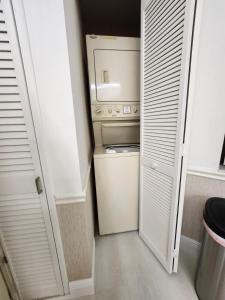 a small kitchen with a refrigerator and a washer and dryer at 2 Cute 2 Pass UP in Orlando