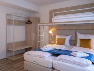 a bedroom with two beds and a bunk bed at Fairschlafen Boutique Hotel in Neustadt in Holstein