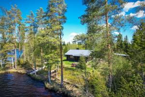 a cabin in the woods next to a river at Artunpirtti in Keuruu +7 photos