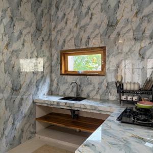 a kitchen with a sink and a stone wall at CASA Habibi in Kuta Lombok +4 photos