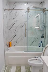 a white bathroom with a shower and a toilet at Comfortable Private Room in Toronto