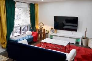 a living room with a couch and a flat screen tv at Comfortable Private Room in Toronto