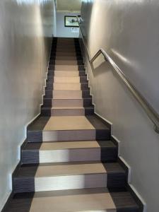 a stairway with a wooden floor and a stair case at Happiness Hotel in Kulai