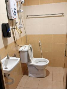 a bathroom with a toilet and a sink at Happiness Hotel in Kulai