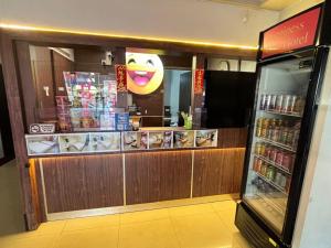 a restaurant with a smiley face behind a counter at Happiness Hotel in Kulai