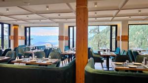 a restaurant with tables and chairs with mountains in the background at Jeeva Premium Rooms in Dalhousie