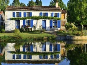 a house with blue doors and a reflection in the water at Chalet avec animaux acceptés - 2 pers. - API-1-52-2308 in Coulon