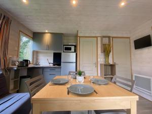 a kitchen and dining room with a wooden table at Chalet clim - 4 pers. - API-1-52-2324 in Coulon
