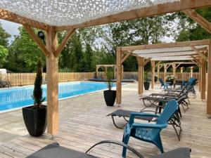 a wooden deck with chairs and a swimming pool at Chalet clim - 4 pers. - API-1-52-2324 in Coulon