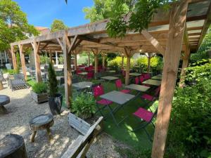 a wooden pavilion with tables and chairs in a garden at Chalet clim - 4 pers. - API-1-52-2324 in Coulon