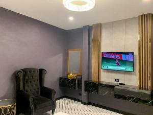 a living room with a tv and a chair at LAFIN resort in Phetchabun