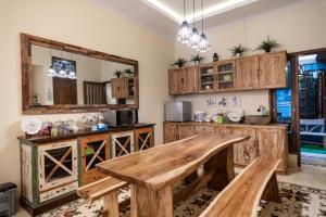 a kitchen with wooden cabinets and a wooden table at Sabi House Lesmana in Timuran