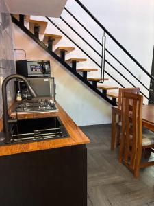 a kitchen with a stove and a staircase at Tiny House Molino Alto in Ciudad Fernández