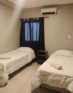 two beds in a room with a window at Fran hotel boutique in Mendoza