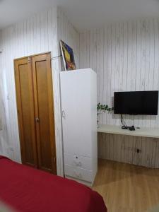 a room with a bed and a tv and a cabinet at Sol house in Pajak