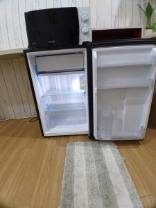 an empty refrigerator with its door open on the floor at Sol house in Pajak