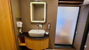 a bathroom with a sink and a mirror at Jeeva Premium Rooms in Dalhousie +25 photos