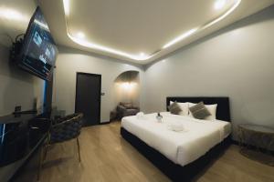 a bedroom with a white bed and a flat screen tv at LAFIN resort in Phetchabun