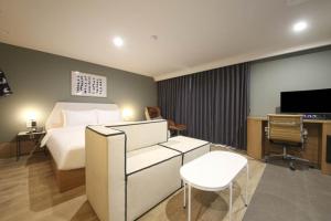 a hotel room with a bed and a tv at 브라운도트 영도 대교점 in Jung-gu
