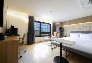 a hotel room with a large bed and a desk at 브라운도트 영도 대교점 in Jung-gu