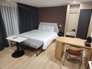 a hotel room with a bed and a table and a desk at 브라운도트 영도 대교점 in Jung-gu