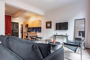 ein Wohnzimmer mit Sofa und Tisch in der Unterkunft Comfort Luxe Loft near Bellas Artes casaXúla in Mexiko-Stadt