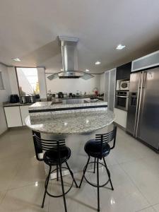 a kitchen with a counter with four bar stools at La Milagrosa in Caracas