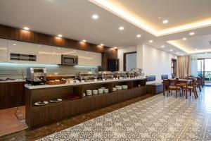 a kitchen with a counter and a dining room at Luxe Paradise Hotel Truc Bach in Hanoi