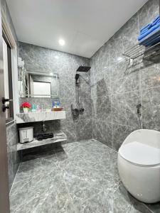 a bathroom with a toilet and a sink and a mirror at Khách Sạn MoonKnight 2 in Sầm Sơn