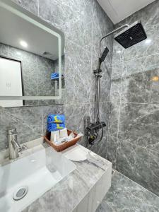 a bathroom with a sink and a shower at Khách Sạn MoonKnight 2 in Sầm Sơn