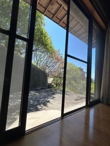 an open glass door with a view of the beach at sakurazaka in Tanabe