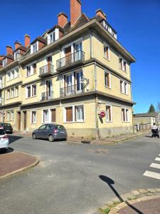 a large yellow building with a car parked in front of it at La Tour d'Harfleur 1 in Caudebec-en-Caux
