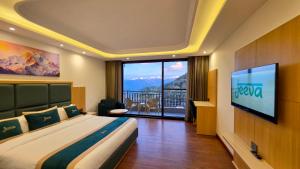 a hotel room with a bed and a tv and a balcony at Jeeva Premium Rooms in Dalhousie