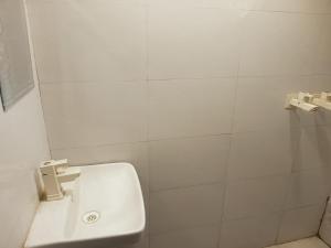 a white bathroom with a sink and a shower at Vrindavan Bunk Hostel by Shiva - 5min Walk from Prem Mandir in Vrindāvan +18 photos